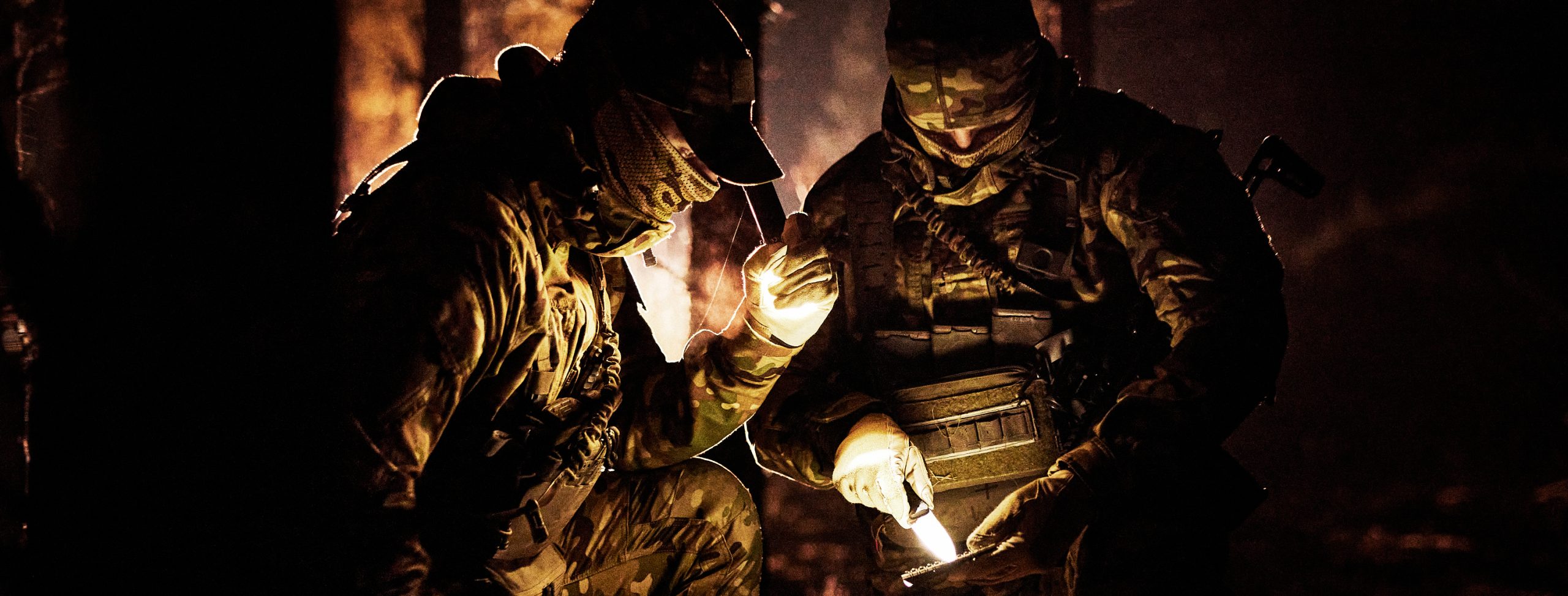militärer tittar på karta med ficklampa i mörker