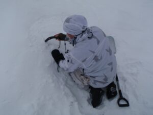 Soldat skär ut form i snö