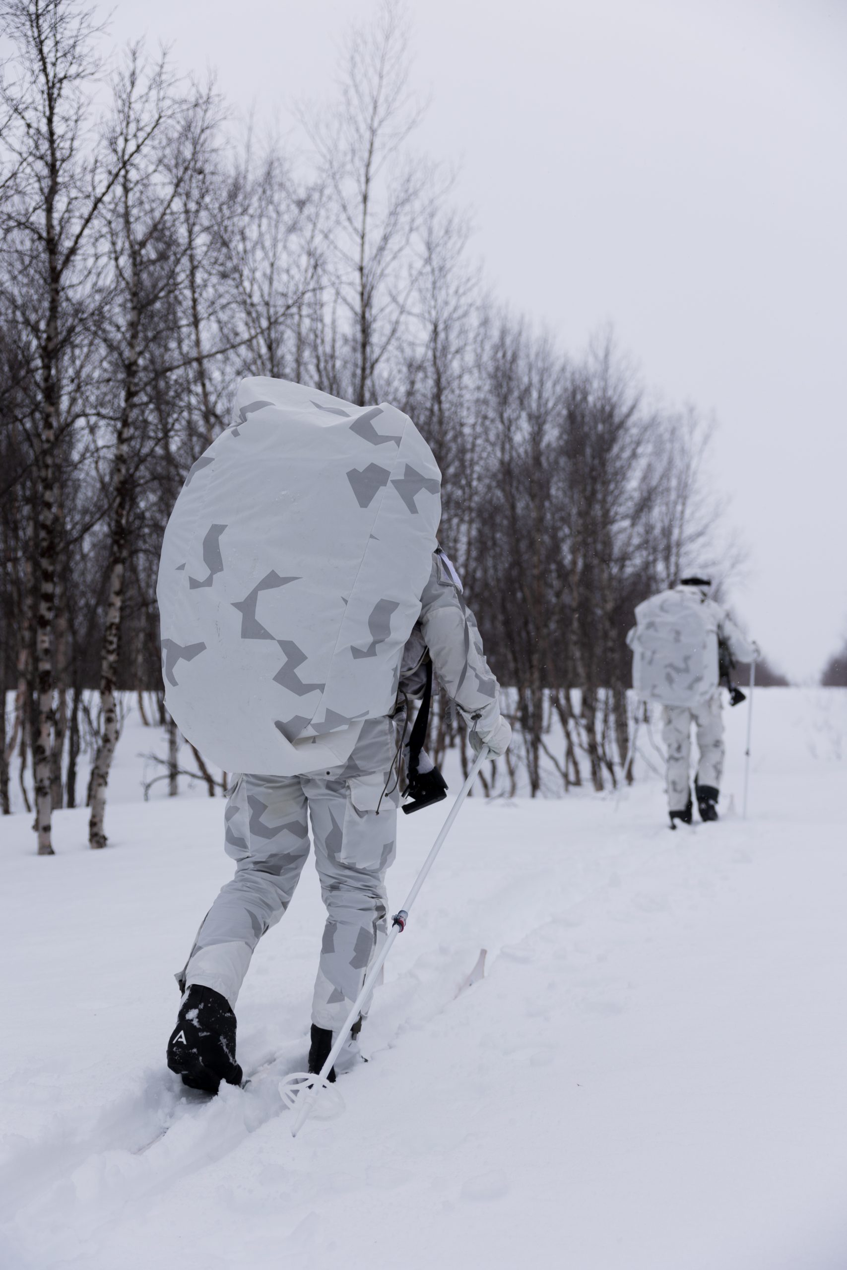 militärer åker skidor med vit camo